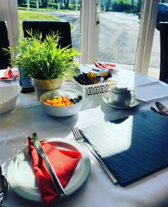 een tafel met borden met eten en keukengerei erop bij Lovesgrove Country Guest House in Pembroke Dock