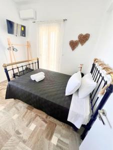 a bedroom with a black bed with two pillows at Petalou House in Imerovigli