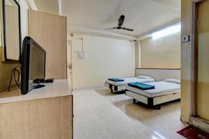 Habitación hospitalaria con 2 camas y TV de pantalla plana en Hotel Vikrant, en Pune
