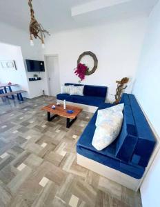 sala de estar con sofá azul y mesa en Petalou House en Imerovigli