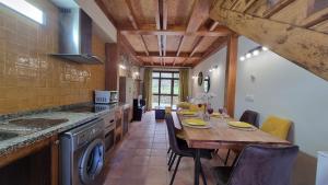 eine Küche mit Holztisch und ein Esszimmer in der Unterkunft Casa Vacacional Los Gemelos in San Roque del Acebal