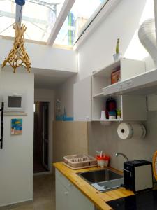 una cucina con lavandino e lucernario di La Domaggera a Maruggio Altre 34 foto