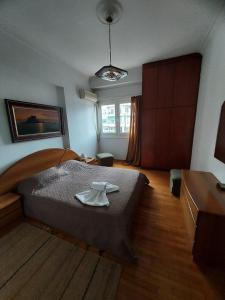 a bedroom with a large bed with a robe on it at Pasalimani Long Beach in Piraeus