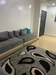 - un canapé dans le salon doté d'un tapis dans l'établissement Casablanca Airport Appartement, à Deroua