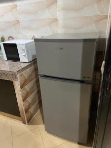 un réfrigérateur dans une cuisine à côté d'un four micro-ondes dans l'établissement Casablanca Airport Appartement, à Deroua