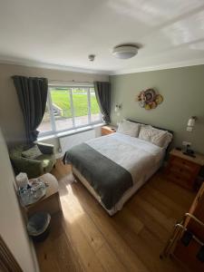 een slaapkamer met een groot bed en een raam bij Lovesgrove Country Guest House in Pembroke Dock