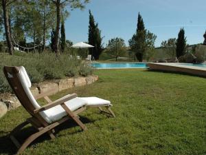 una sedia seduta sull'erba accanto alla piscina di Villa Val delle Vigne a Diaccialone