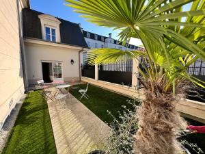 eine Palme im Hof eines Hauses in der Unterkunft Lifestyle Disneyland Paris 8 PAX in Serris