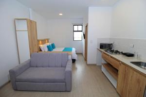 - un salon avec un canapé et un lit dans l'établissement APART HOTEL CASA BLANCA, à Cuenca