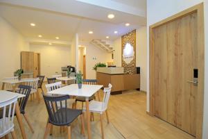 a dining room with tables and chairs and a door at APART HOTEL CASA BLANCA in Cuenca