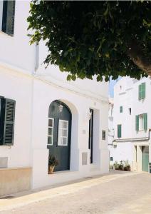 um edifício branco com uma porta verde numa rua em MAISON HÔTEL SES PENYES em Alaior