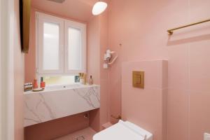 a bathroom with a toilet and a sink and a window at Old Town Hall Apartment in Corfu Town +48 photos