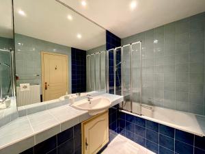 a blue tiled bathroom with a sink and a tub at Le Logis Plantagenêt in Bergerac +27 photos