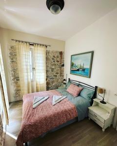ピタゴリオにあるStone Villaのベッドルーム1室(ベッド1台、タオル2枚付)