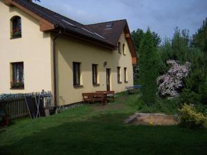 ein Haus mit einem Picknicktisch und einer Bank im Hof in der Unterkunft Chalupa Pod Melechovem in Světlá nad Sázavou