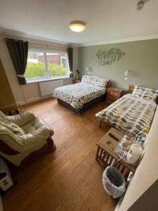 een kamer met 2 bedden, een bank en een tafel bij Lovesgrove Country Guest House in Pembroke Dock