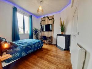 - une chambre avec un lit bleu et une cheminée dans l'établissement Le Cocon, à Rennes
