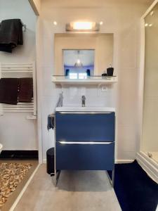 La salle de bains est pourvue d'un lavabo bleu. dans l'établissement Le Cocon, à Rennes