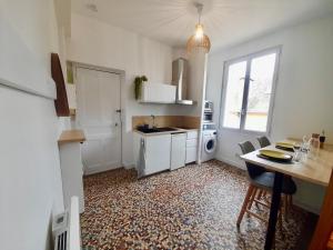 a kitchen with a table and a sink and a stove at Le Cocon in Rennes