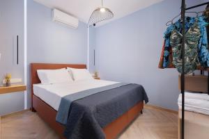 um quarto com uma cama com um cobertor azul em Old Town Hall Apartment em Corfu Town