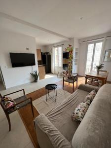 a living room with a couch and a flat screen tv at Joli appartement d'artiste 44m2 in Nice