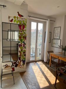 a room with a table and a window with a bird on the wall at Joli appartement d'artiste 44m2 in Nice