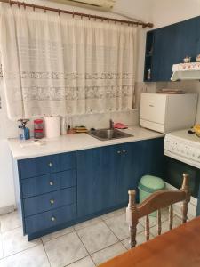 - une cuisine avec des placards bleus et un évier dans l'établissement Spitaki mou, à Kamena Vourla