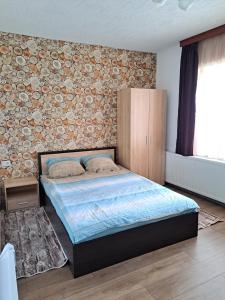- une chambre avec un lit et un mur en briques dans l'établissement Вила Слънчев Бряг, à Dospat