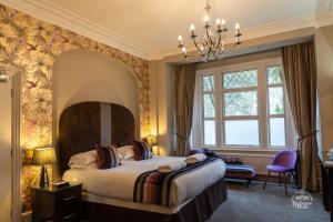 a bedroom with a bed and a chandelier at Burlington House Boutique in Oxford