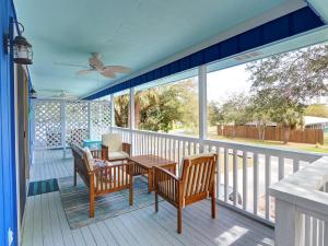 eine abgeschirmte Veranda mit einem Tisch und Stühlen sowie einem Deckenventilator in der Unterkunft Deja Blue A & B in Tybee Island