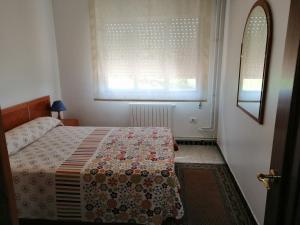 um quarto com uma cama com um cobertor florido e uma janela em Cachadiña em Marín
