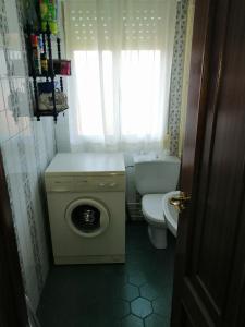 a small bathroom with a toilet and a washing machine at Cachadiña in Marín