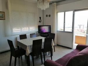 uma sala de jantar com uma mesa e cadeiras e uma televisão em Cachadiña em Marín