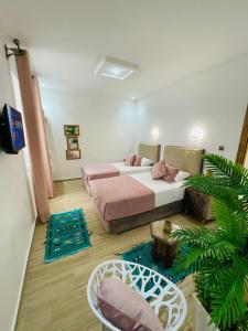 a bedroom with two beds with rugs in it at Hotel Palace tanger in Tangier