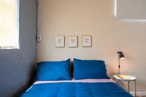 a bedroom with a blue bed with two pictures on the wall at Private Studio Good Vibes in Miami