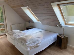ein Schlafzimmer mit einem weißen Bett im Dachgeschoss in der Unterkunft Hegedal Apartment in Hobro