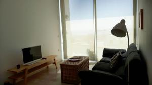 a living room with a couch and a large window at APARTAMENTO TURÍSTICO CARBONERAS in Carboneras