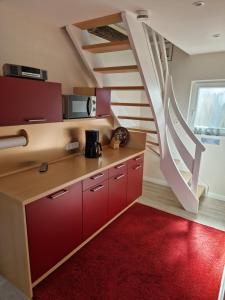 a kitchen with red cabinets and a spiral staircase at Altes Zollhaus in Fehmarn