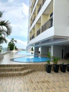 a building with a swimming pool next to the ocean at 12-10 Twin bedroom in Formosa Residence Nagoya Batam 3 pax by Wiwi in Nagoya