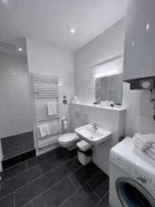 biała łazienka z umywalką i toaletą w obiekcie Apartment & Boardinghouse Berlin Friedrichshain-Kreuzberg w Berlinie