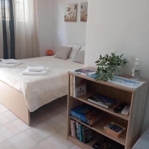 a bedroom with a bed and a book shelf with books at Studio Victory Chania in Chania Town