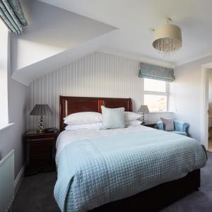 1 dormitorio con 1 cama grande con manta azul en Luxury Lodges in Doolin Village with Hot Tubs, en Doolin