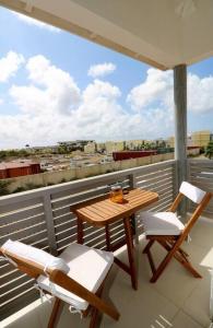 una mesa y sillas en un balcón con vistas en Stylish Apartment with Swimming Pool, en Kralendijk