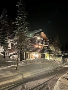 Una casa en la nieve por la noche en SKI INN/OUT - 4-room apartment w/3 bedroom, en Gaustablikk