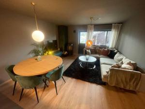 een woonkamer met een tafel en een bank bij SKI INN/OUT - 4-room apartment w/3 bedroom in Gaustablikk