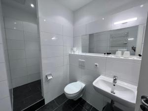 biała łazienka z toaletą i umywalką w obiekcie Apartment & Boardinghouse Berlin Friedrichshain-Kreuzberg w Berlinie