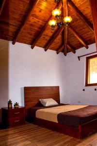 1 dormitorio con cama y techo de madera en Comunidad La Moya, Calpi, en Riobamba