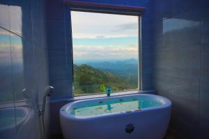 a bathroom with a tub and a window with a view at Ro Yo Rock Ella in Ella