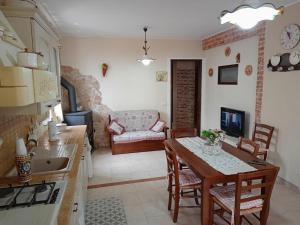 cocina y sala de estar con mesa y sofá en Belvedere Apartment en SantʼAlfio