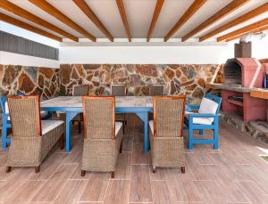 a dining room with a blue table and chairs at Villa Luxury Paula's Dream Private Pool Corralejo By Holidays Home in Corralejo